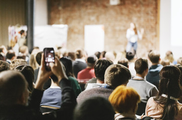  Dorośli studenci słuchają mówcy na widowni. Widok z tyłu