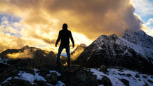 Silhouette On Epic Mountain Peak Of Man Standing On Summit