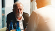 © Mongkolchon - portrait of senior businessman with beard in business suit having business talk with business colleague