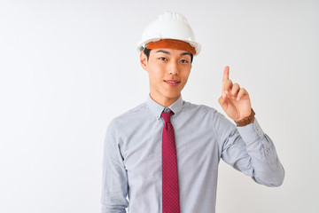 Wall Mural - Chinese architect man wearing tie and helmet standing over isolated white background showing and pointing up with finger number one while smiling confident and happy.