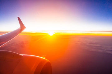 Beautiful aerial view from airplane wing on white cloud and sky at sunset time