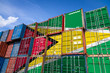 The national flag of Guyana on a large number of metal containers for storing goods stacked in rows on top of each other. Conception of storage of goods by importers, exporters