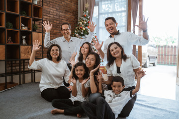 Wall Mural - excited asian family with grandparent raised their arm during christmas at home