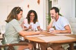 © Krakenimages.com - Beautiful family sitting on terrace drinking cup of coffee using smartphone speaking and smiling