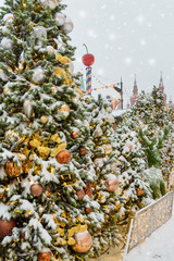 Wall Mural - Christmas trees decorated with balls and lights, garlands covered with snow on Red Square in the evening. Moscow