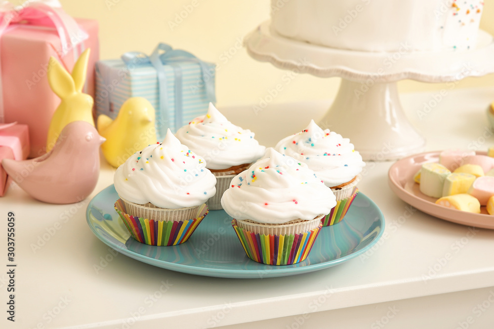Plate with tasty Birthday cupcakes on table
