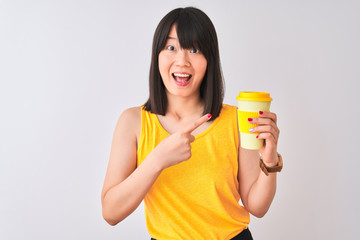 Wall Mural - Young beautiful Chinese woman drinking take away coffee over isolated white background very happy pointing with hand and finger