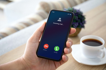 male hands holding phone with incoming call on the screen