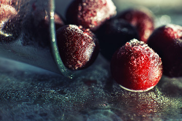 closeup frozen cherry in the glass with reflection . frozen cherry  on a dark background macro