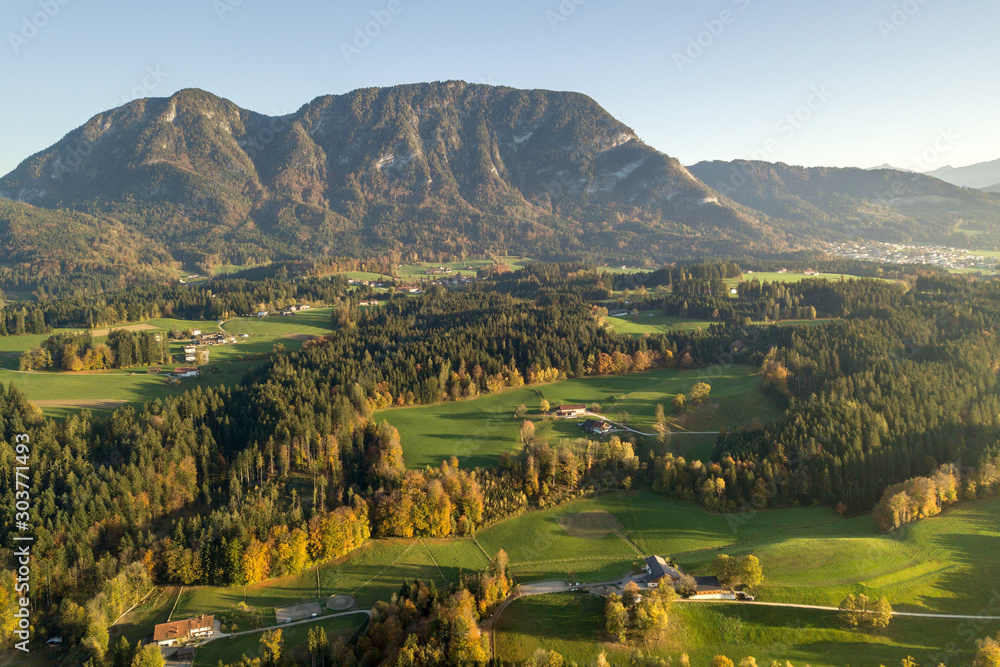 Aerial view of green meadows with villages and forest in austrian Alps ...