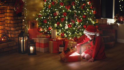 Wall Mural - happy laughing child girl with magic gift on christmas eve
