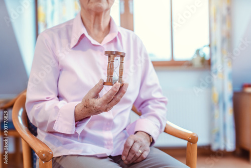 Cuadros en Lienzo Senior in nursing home holding a hourglass - time is running up