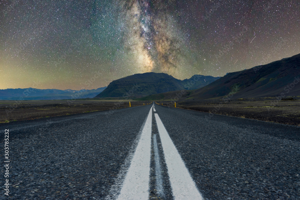 Milky way over mountains at the end of a long road. Scenery and night photography concept.......... - obrazy, fototapety, plakaty 