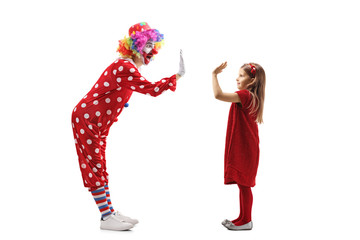 Wall Mural - Funny clown making high-five gesture with a little girl