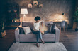 High angle view photo of amazing dark skin curly lady browsing notebook texting with friends sitting cozy sofa wear casual sweater jeans clothes evening flat indoors