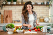 © JustLife - Young woman in kitchen. Beautiful woman making salad.