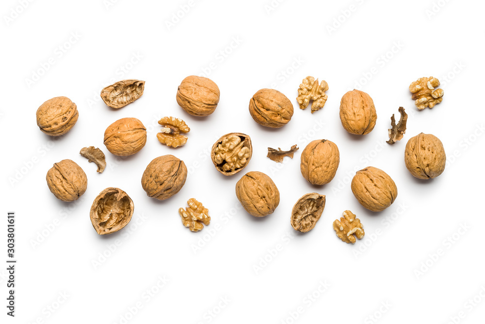 top view of walnuts closed and broken scattered on a white background with copy space - obrazy, fototapety, plakaty 