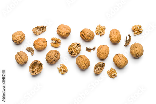 Fotografía top view of walnuts closed and broken scattered on a white background with copy
