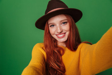 Wall Mural - Redhead woman take a selfie by camera.