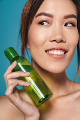 Poster - Asian young woman holding bottle with toner.