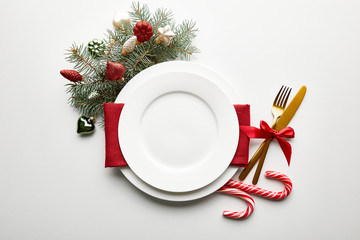 Canvas Print - top view of festive Christmas table setting on white background with decoration, pine branch and candies