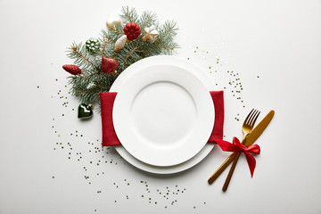 Wall Mural - top view of festive christmas table setting on white background with decorated pine branch and confe