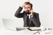 © timtimphoto - Stressed bearded brunette male sitting at working table and having tense phone conversation, rumpling his hair with confused face and looking puzzled aside, dressed in grey suit