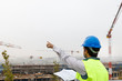 © Ignacio Ferrándiz - Architect pointing towards a part of the building under construction while looking at some plans