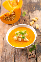 Wall Mural - pumpkin soup in bowl with crouton on wood background