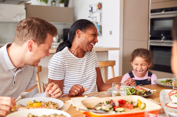 Wall Mural - Multi-Generation Mixed Race Family Eating Meal Around Table At Home Together