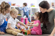 © Oksana Kuzmina - Little toddlers kid boy and child girl with moms playing together in nursery room. Preschool children in day care centre