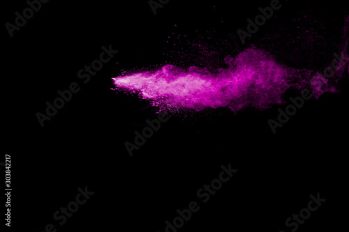 Purple color powder explosion cloud on black background.Closeup of purple dus...