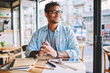 © BullRun - Handsome smiling smart male entrepreneur enjoying work break and pondering about creative ideas for business startup.Mature clever positive man in stylish eyeglasses looking away while sitting in cafe