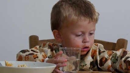 Wall Mural - Adorable little boy two years eating pasta indoor