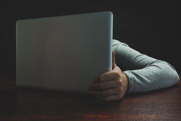 Aufkleber - Close up Man sitting laptop on a red wooden table. Beautiful black background