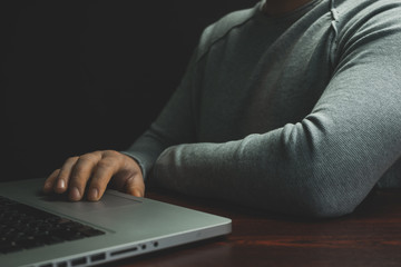 Aufkleber - Close up Man sitting laptop on a red wooden table. Beautiful black background