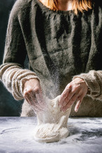Process Of Making Homemade Bread Dough. Female Hands Kneading Dough On Dark Kitchen. Black Table With Flour. Home Bread Baking. Photo Series.