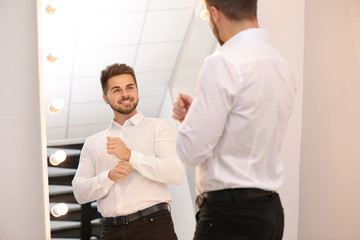 Poster - Young man looking at himself in large mirror at home