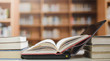 © Ping198 - Stack of books in the library and blur bookshelf background