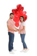 Wall Mural - Happy young couple with heart shaped balloons isolated on white. Valentine's day celebration