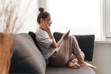 Image Of Concentrated Woman Using Cellphone While Sitting On Sofa