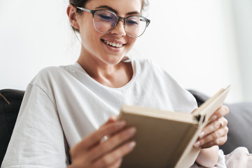 Sticker - Image closeup of joyful caucasian woman reading book while sitting