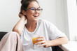 Image of laughing nice woman looking aside and drinking juice