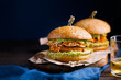 Vegan sweet potato chickpea burgers with avocado guacamole sauce and carrot slaw on dark blue background with copy space for text.Vegetarian meal,plant based food concept.Horizontal orientation