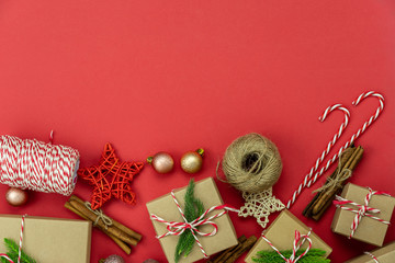 Wall Mural - Table top view of Merry Christmas decorations & Happy new year ornaments concept.Flat lay essential difference objects gift box & fir tree on modern red paper background at home studio office desk.