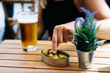 Point Of View Of Woman With Glass Of Beer In A Bar And Olives