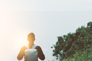 Wall Mural - Copy space of backpack man looking view of beach with blue sky background.