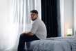 © New Africa - Depressed overweight man on bed at home