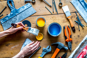 building decoration instruments with paint, brush, palette-knife on wooden background top view