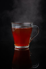 cup of black tea with steam on a dark background